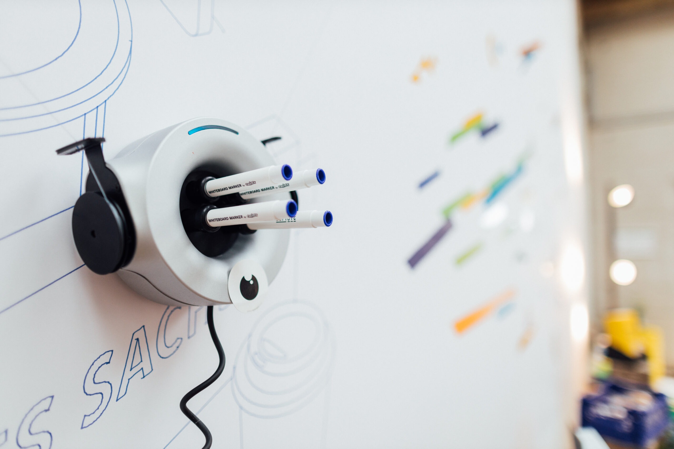 Fünf Stifte hängen in einem automatischen Gerät und malen auf ein Papier